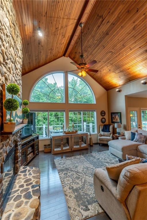 living room featuring a wealth of natural light, beam ceiling, ceiling fan, and dark wood-type flooring