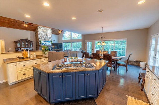 kitchen with pendant lighting, white cabinets, and a healthy amount of sunlight