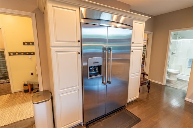 kitchen with built in refrigerator, white cabinets, and dark hardwood / wood-style flooring