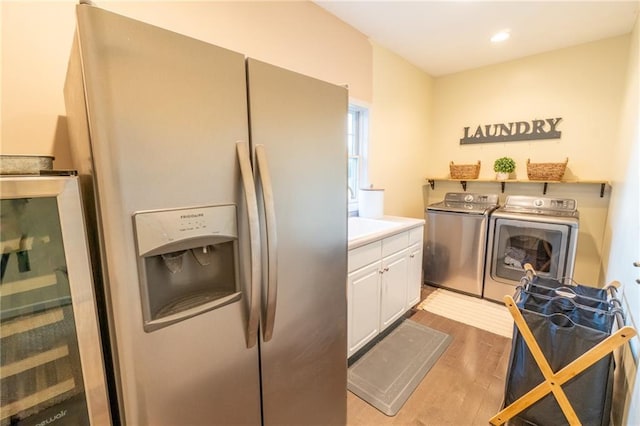 kitchen with separate washer and dryer, light hardwood / wood-style flooring, white cabinets, and stainless steel fridge with ice dispenser