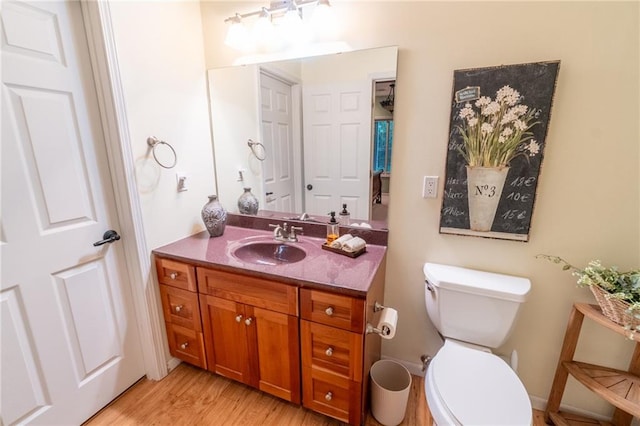 bathroom featuring hardwood / wood-style floors, vanity, and toilet