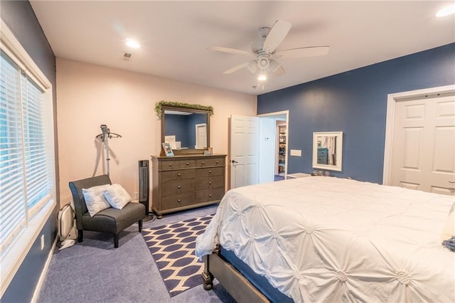 carpeted bedroom featuring multiple windows and ceiling fan