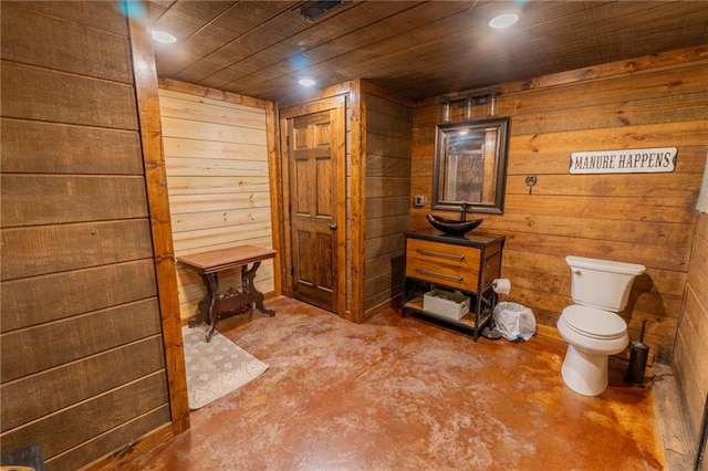 bathroom featuring wood ceiling, a wood stove, wooden walls, vanity, and toilet