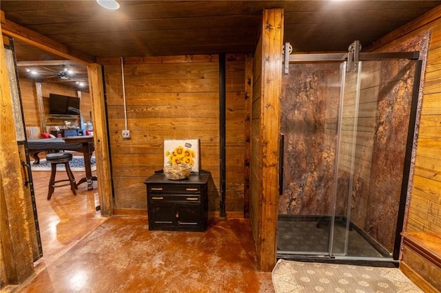 bathroom with wood walls, a shower with door, concrete flooring, ceiling fan, and wooden ceiling