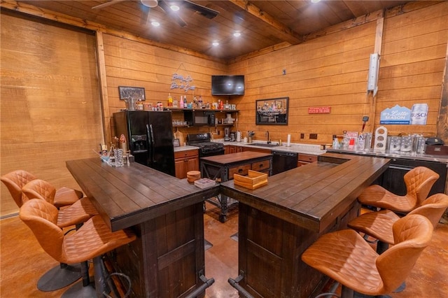 interior space featuring wood ceiling, beam ceiling, wood walls, ceiling fan, and wet bar