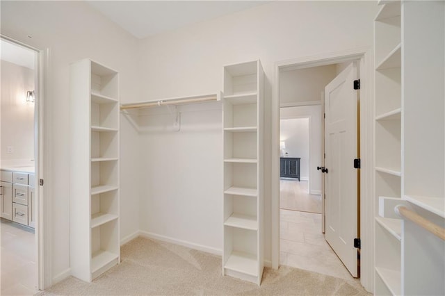 walk in closet featuring light colored carpet