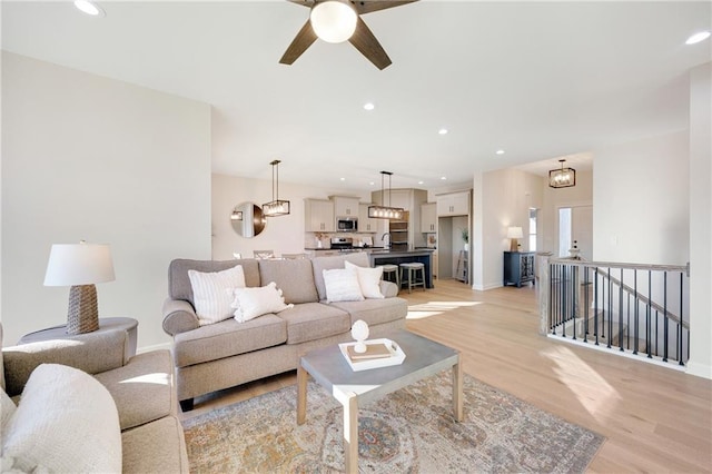 living room featuring light hardwood / wood-style flooring and ceiling fan