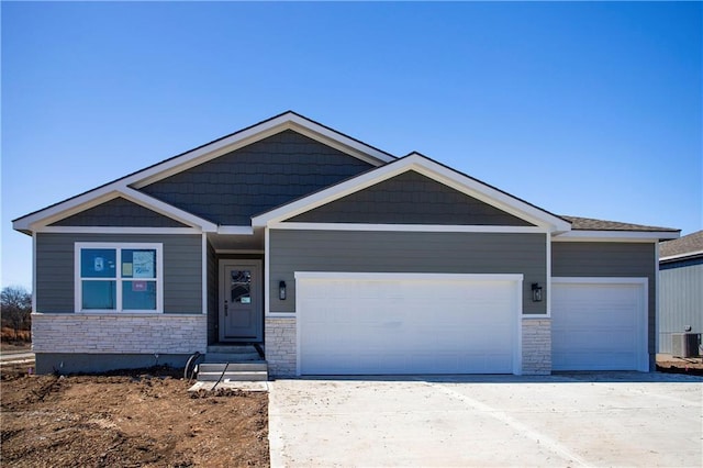 craftsman-style house with concrete driveway, stone siding, an attached garage, and central air condition unit