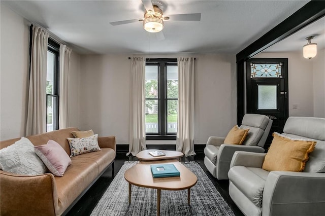 living room with ceiling fan and dark hardwood / wood-style floors