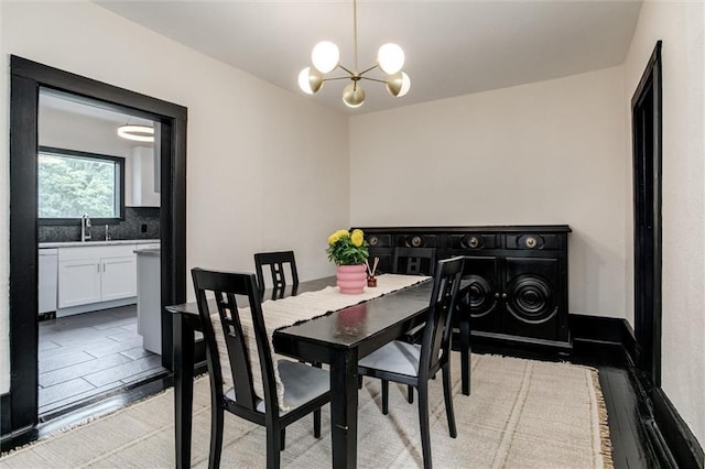 dining area with light hardwood / wood-style flooring, an inviting chandelier, and sink