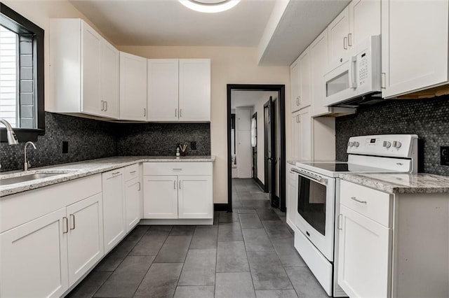 kitchen with white cabinetry, white appliances, and sink