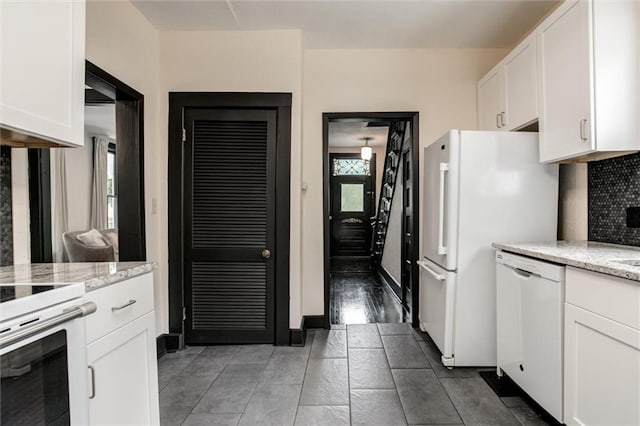 kitchen with backsplash, light stone counters, white appliances, dark wood-type flooring, and white cabinets