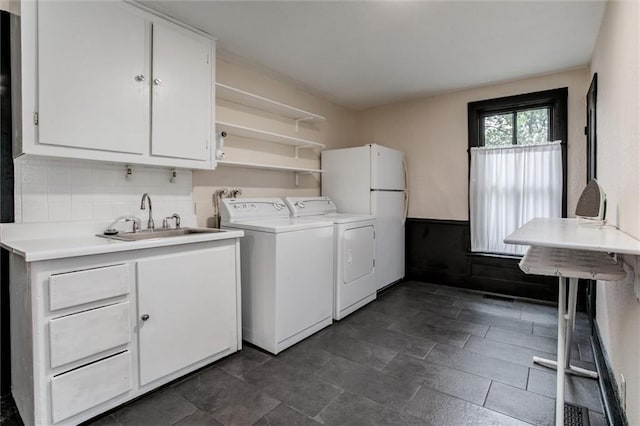 laundry area featuring cabinets, independent washer and dryer, and sink