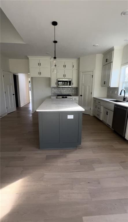 kitchen featuring hanging light fixtures, sink, dishwasher, and decorative backsplash