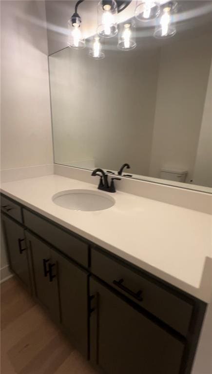 bathroom with wood-type flooring, vanity, and toilet