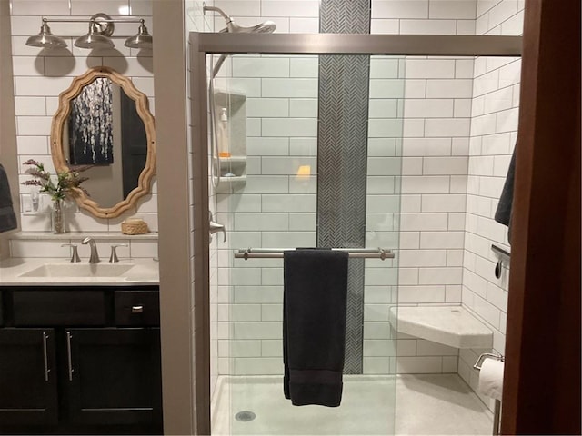 bathroom featuring tile walls, a shower with door, and vanity with extensive cabinet space