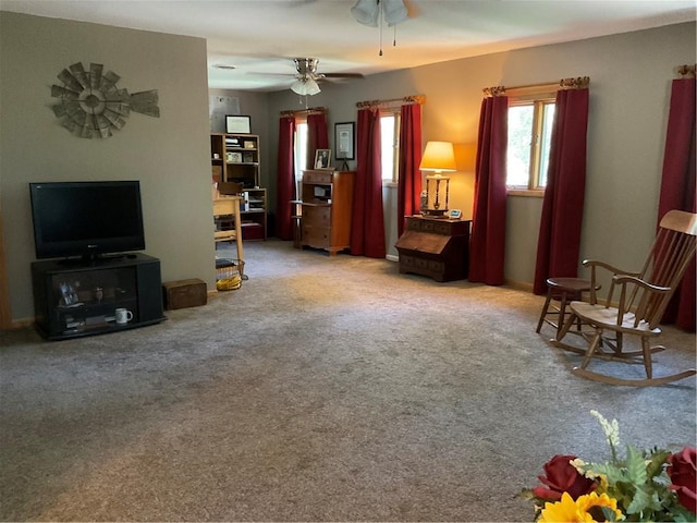 living area with carpet and ceiling fan