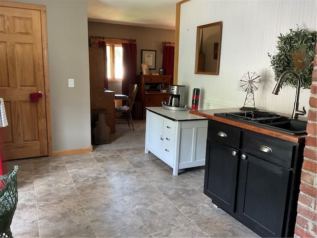 kitchen with sink, white cabinets, and light tile floors