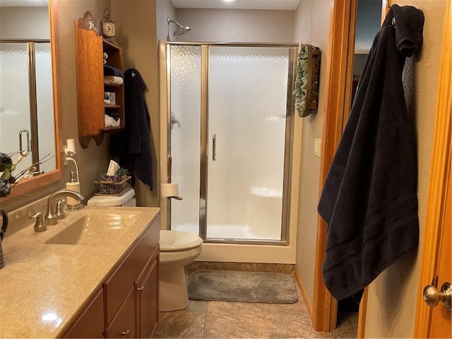 bathroom with vanity with extensive cabinet space, walk in shower, toilet, and tile floors