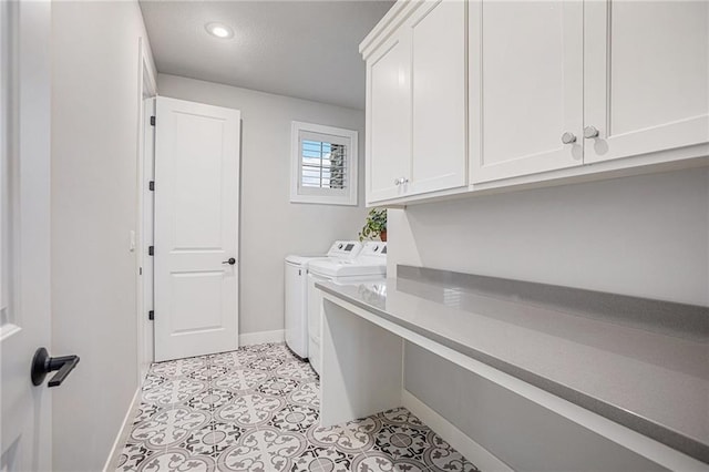 clothes washing area featuring light tile patterned flooring, cabinets, and washer and clothes dryer