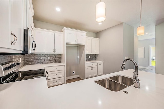 kitchen featuring white cabinets, stainless steel appliances, hanging light fixtures, and sink