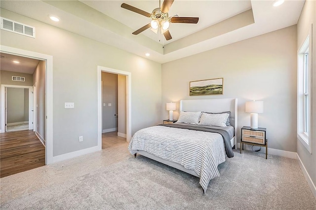 bedroom featuring a tray ceiling, ceiling fan, and carpet flooring