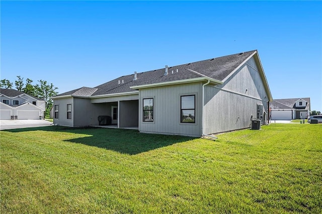 rear view of house featuring a yard and central air condition unit