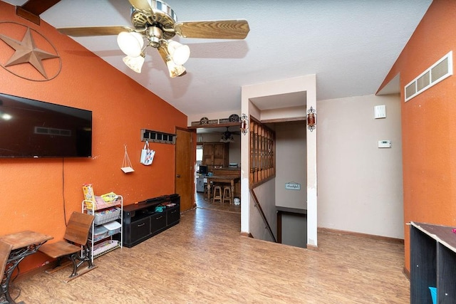 interior space featuring wood-type flooring, ceiling fan, and lofted ceiling