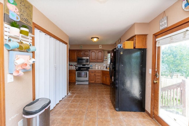 kitchen featuring decorative backsplash, stainless steel appliances, and light tile patterned flooring