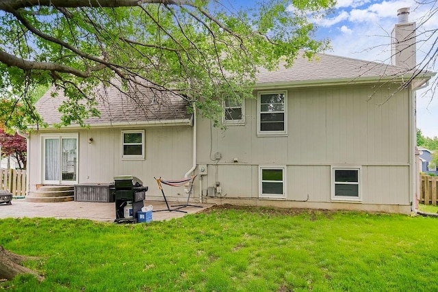 back of property with a yard and a patio area