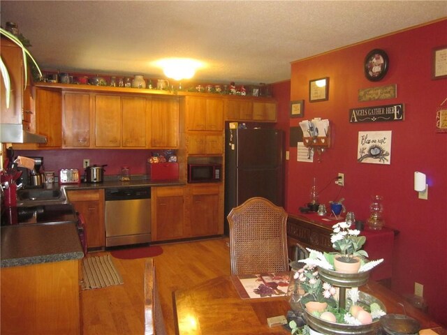 kitchen with sink, black appliances, and light hardwood / wood-style flooring