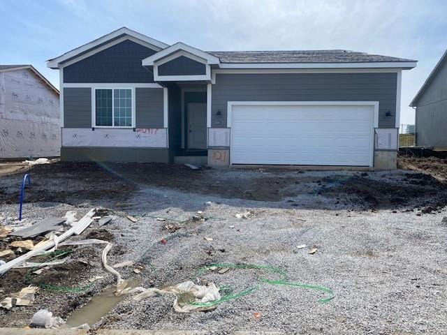 view of front of house featuring dirt driveway and an attached garage