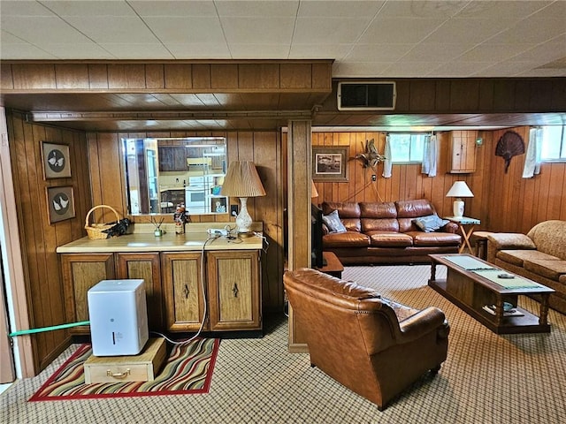 carpeted living room with wood walls