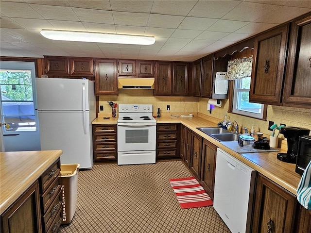 kitchen featuring tasteful backsplash, dark brown cabinets, sink, white appliances, and light tile floors