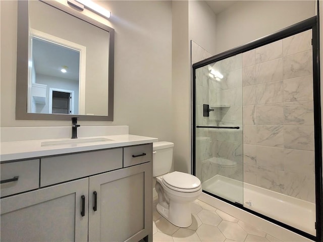 bathroom featuring tile patterned floors, vanity, walk in shower, and toilet