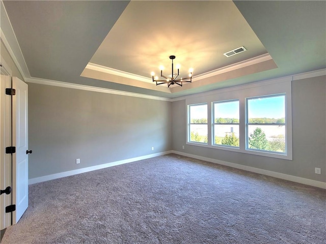 carpeted empty room with baseboards, visible vents, a tray ceiling, and a notable chandelier