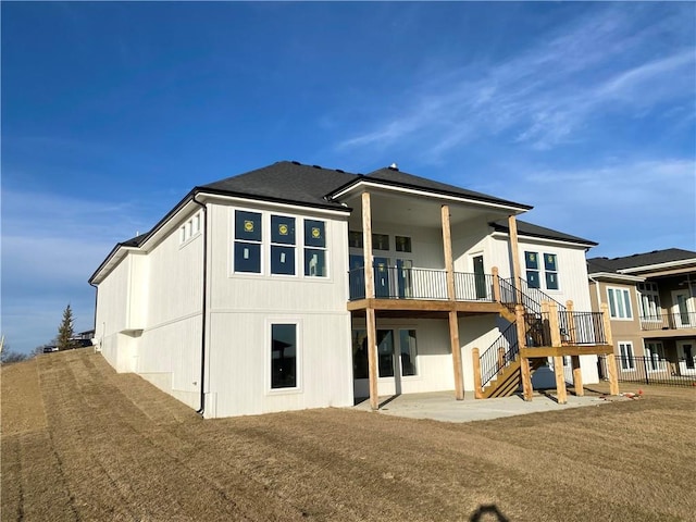 rear view of house featuring a lawn and a patio area