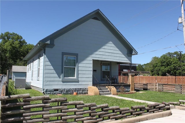 back of house with covered porch and a yard