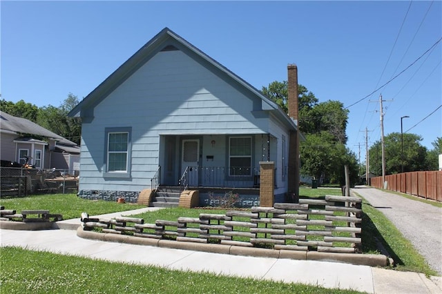 bungalow-style home with covered porch and a front lawn