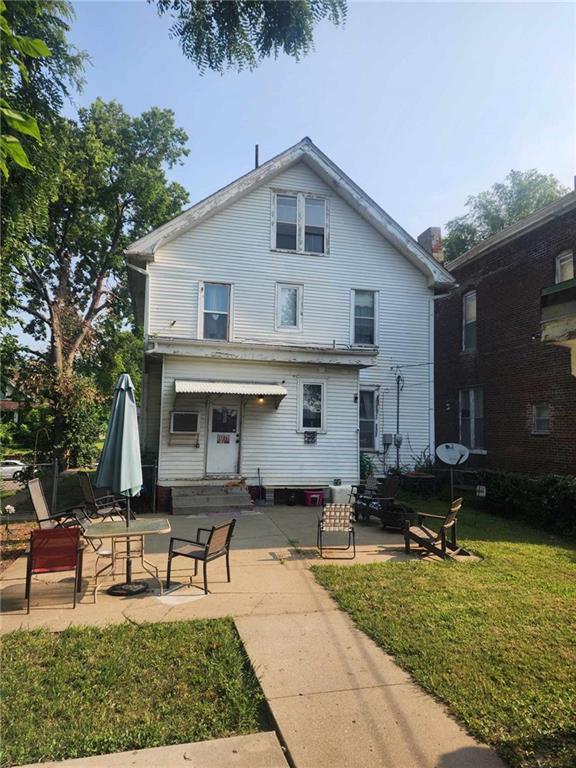 view of front facade with a patio area, a front lawn, and entry steps