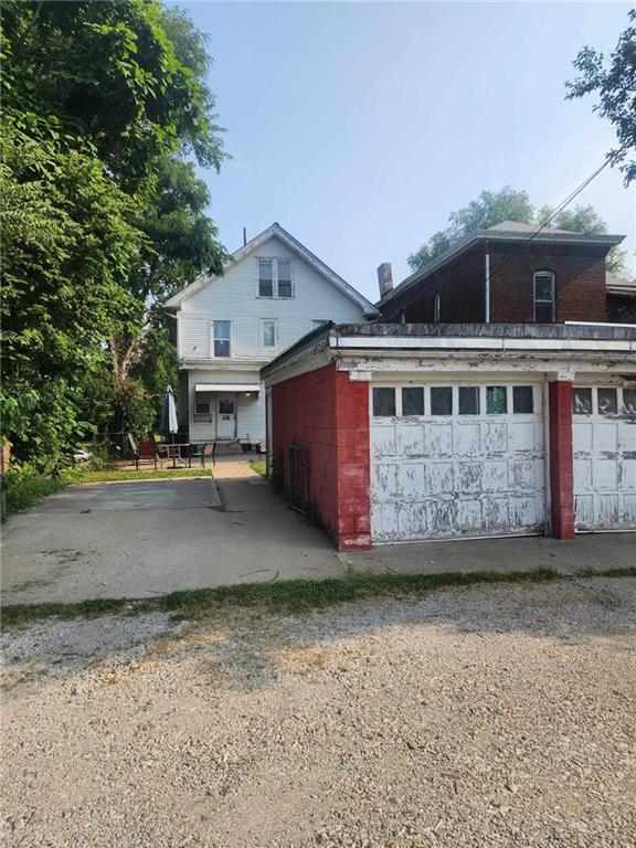 view of side of property with a garage, concrete block siding, and an outbuilding