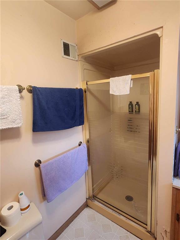 bathroom featuring visible vents and a shower stall