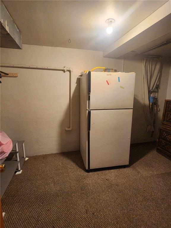 kitchen with carpet floors and freestanding refrigerator