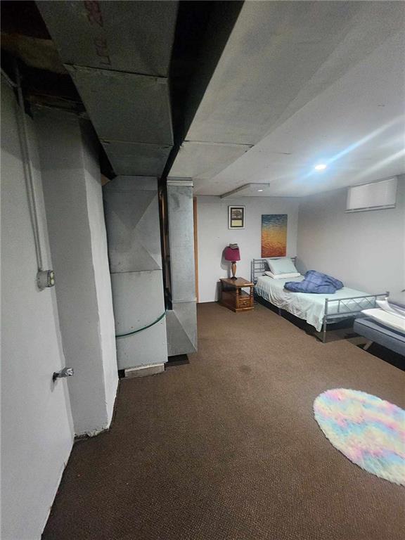 bedroom featuring a wall mounted air conditioner and dark carpet