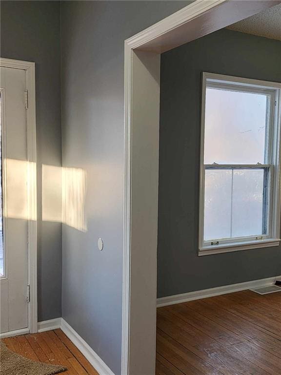 interior space with visible vents, baseboards, and hardwood / wood-style floors