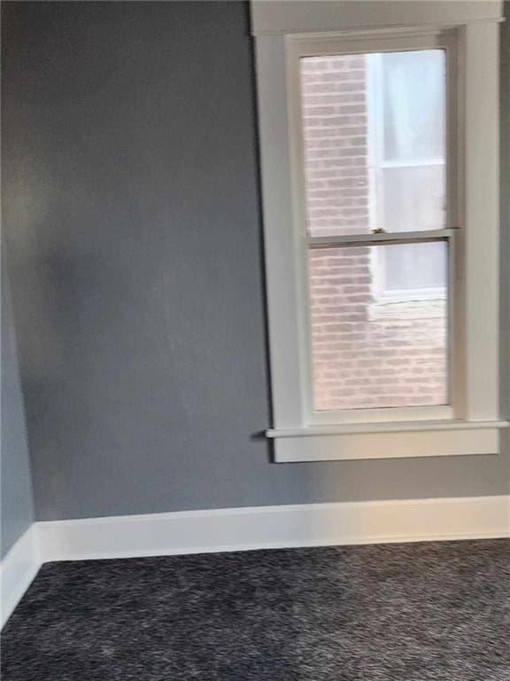 unfurnished room with carpet flooring and baseboards