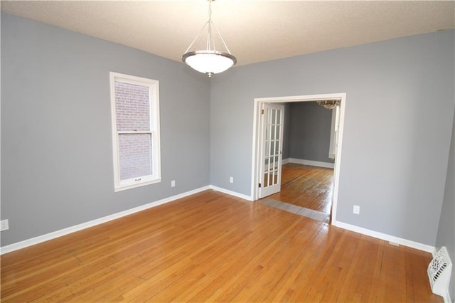 spare room featuring french doors, visible vents, baseboards, and light wood finished floors