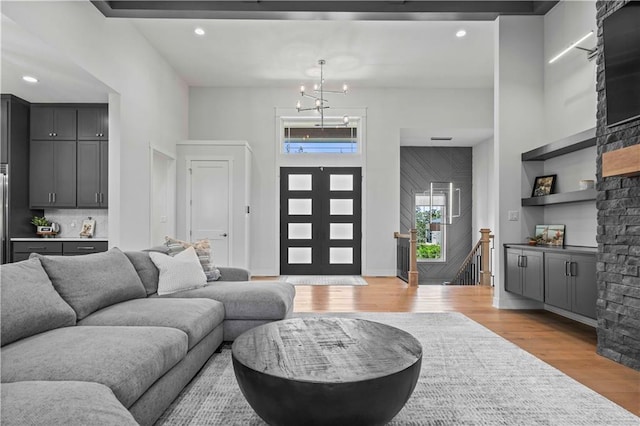 living room with a high ceiling, light hardwood / wood-style flooring, and a chandelier