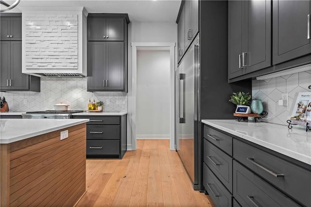 kitchen with light hardwood / wood-style flooring, range, gray cabinets, and high quality fridge