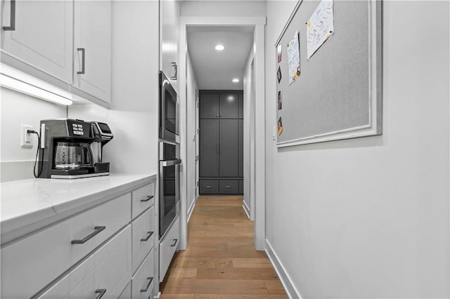 kitchen featuring light stone counters, stainless steel appliances, white cabinets, and dark hardwood / wood-style flooring